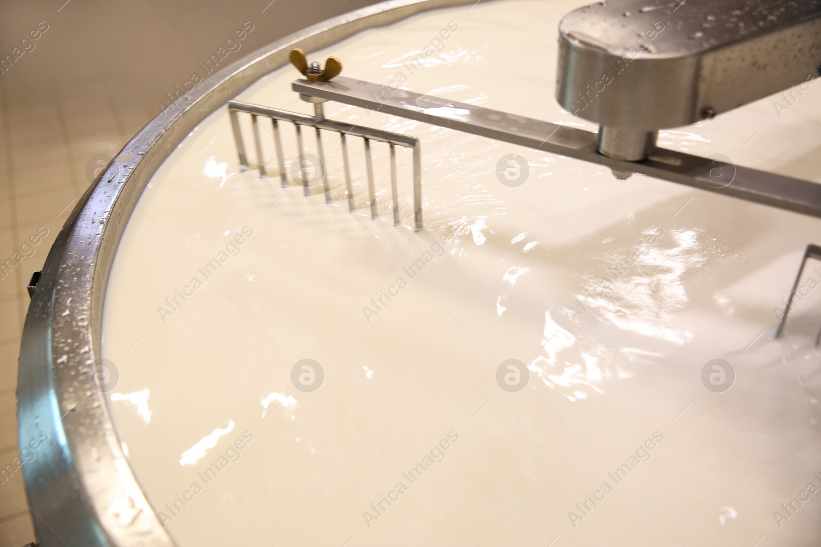 Photo of Milk in curd preparation tank at cheese factory, closeup