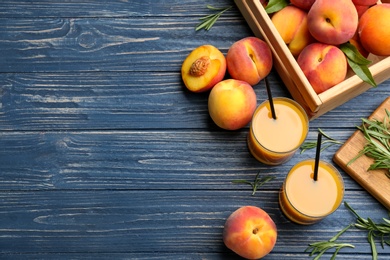 Photo of Natural peach juice and fresh fruits on blue wooden table, flat lay. Space for text