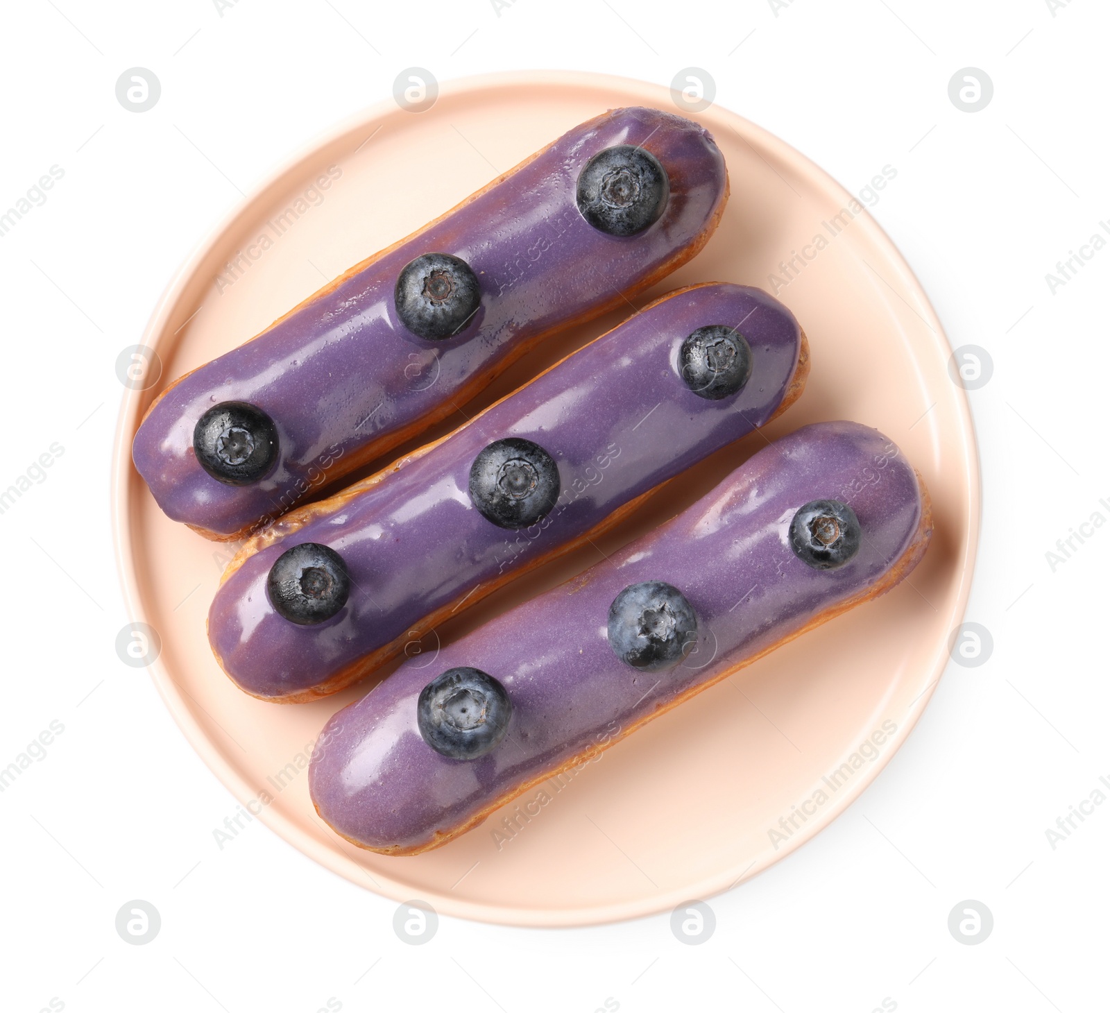 Photo of Delicious eclairs decorated with blueberries isolated on white, top view