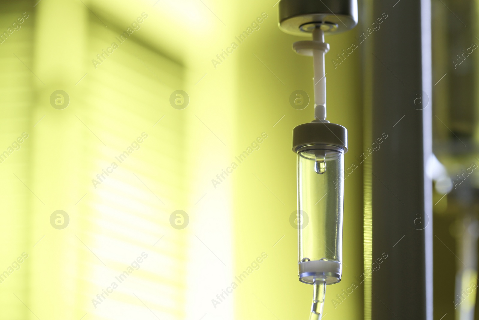 Photo of IV drip against blurred yellow background, space for text