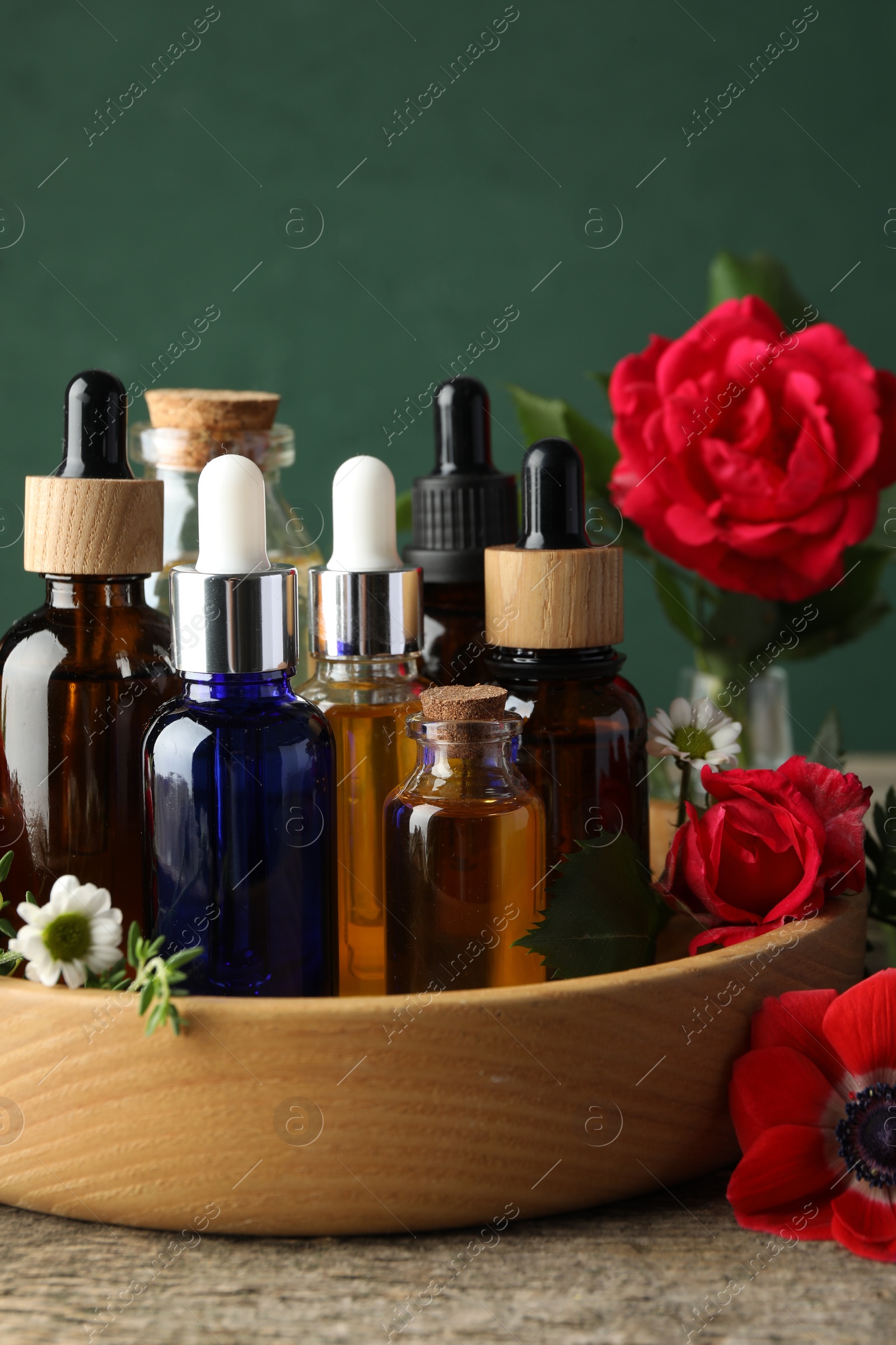 Photo of Aromatherapy. Different essential oils and flowers on wooden table