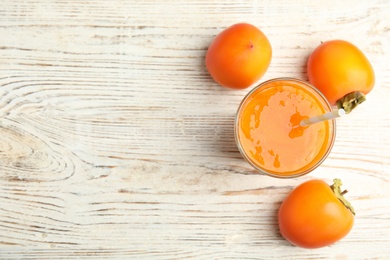 Photo of Tasty persimmon smoothie and fresh fruits on white wooden table, flat lay. Space for text