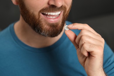 Photo of Closeup view of bearded man taking pill