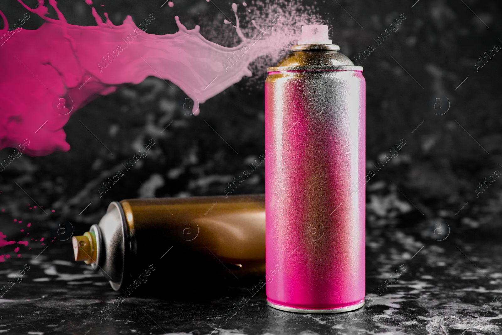 Image of Cans of spray paint on black marble background