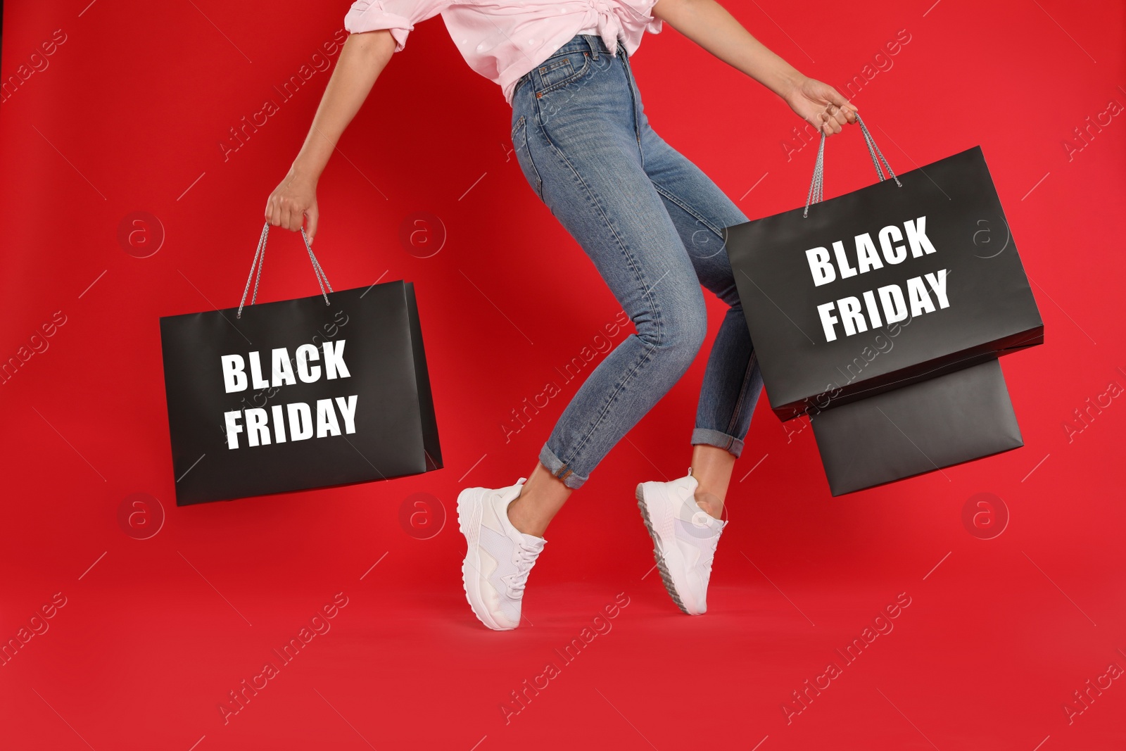 Photo of Woman with shopping bags on red background, closeup. Black Friday