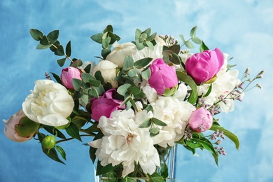 Vase with bouquet of beautiful flowers on color background