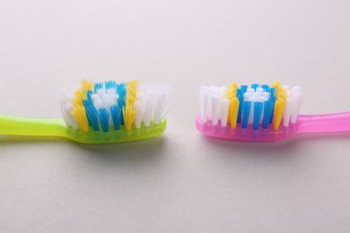 Photo of Colorful plastic toothbrushes on light background, closeup