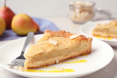 Piece of delicious sweet pear tart on table, closeup