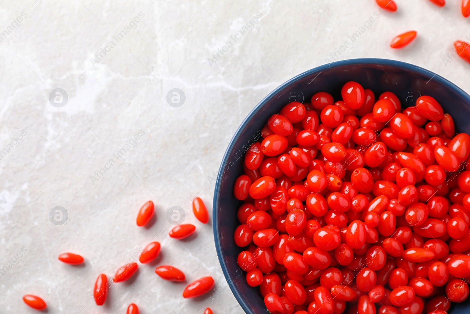 Photo of Fresh ripe goji berries on marble table, flat lay. Space for text