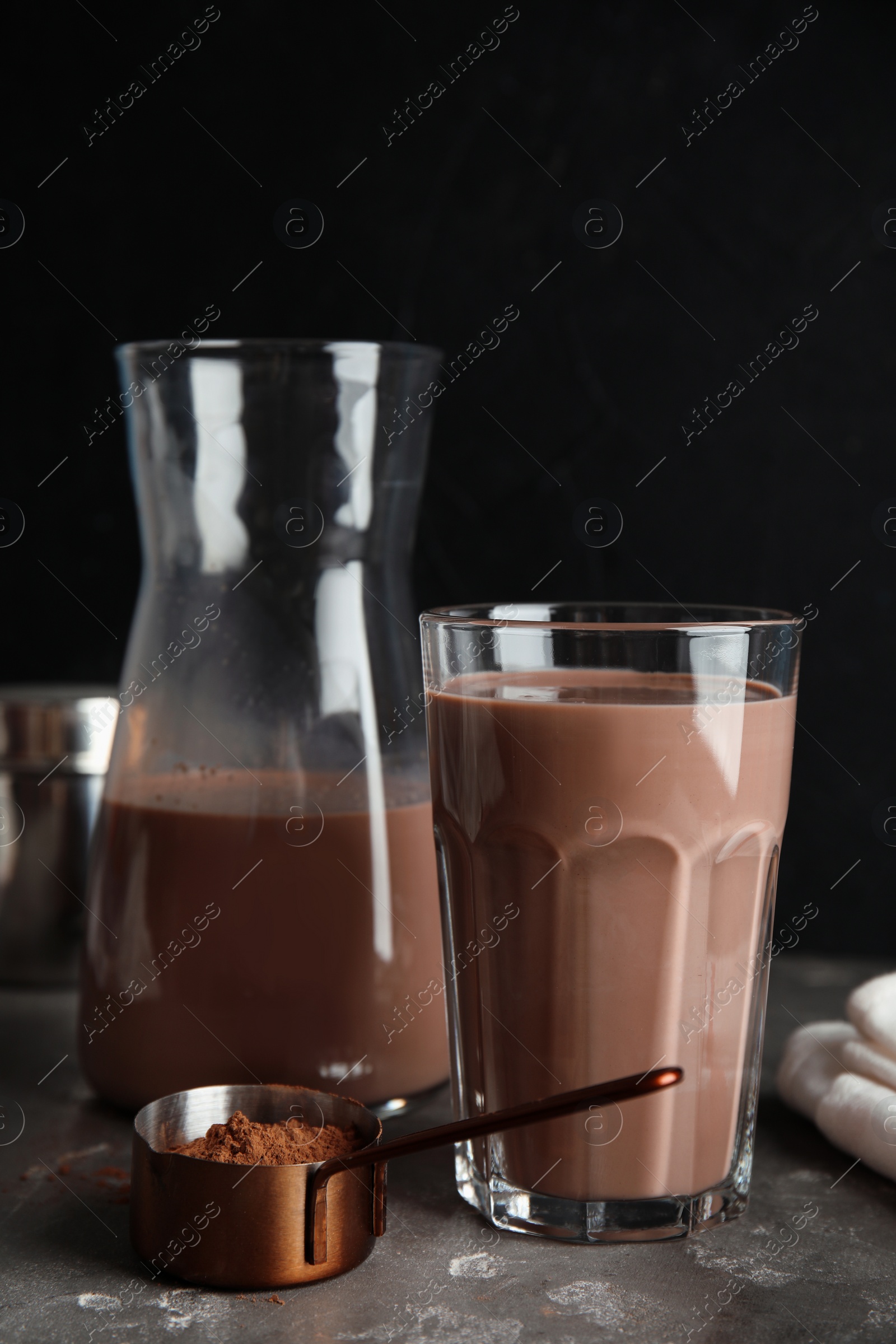 Photo of Glass with tasty chocolate milk on gray table. Dairy drink