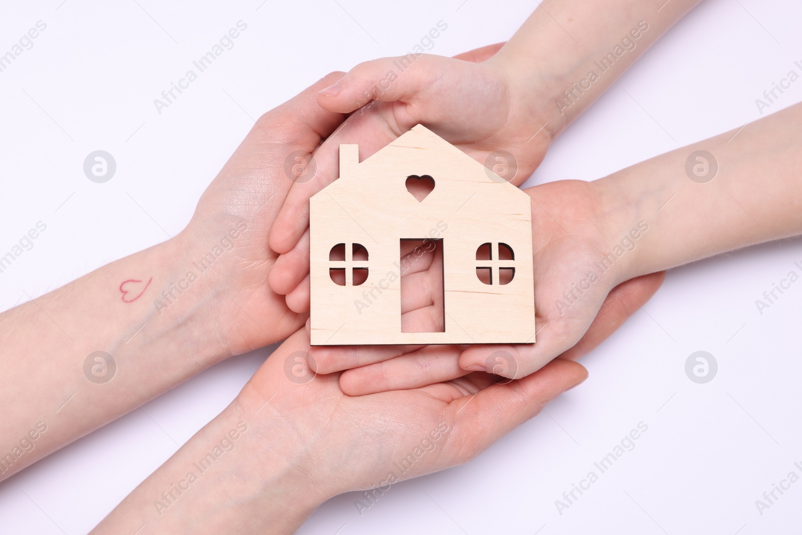 Photo of Home security concept. Woman with her little child holding house model on white background, top view