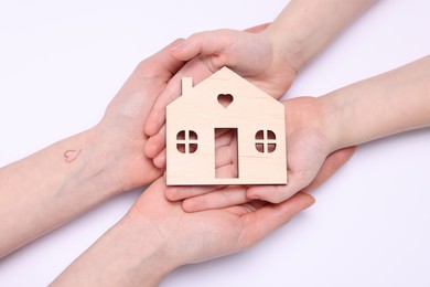 Photo of Home security concept. Woman with her little child holding house model on white background, top view
