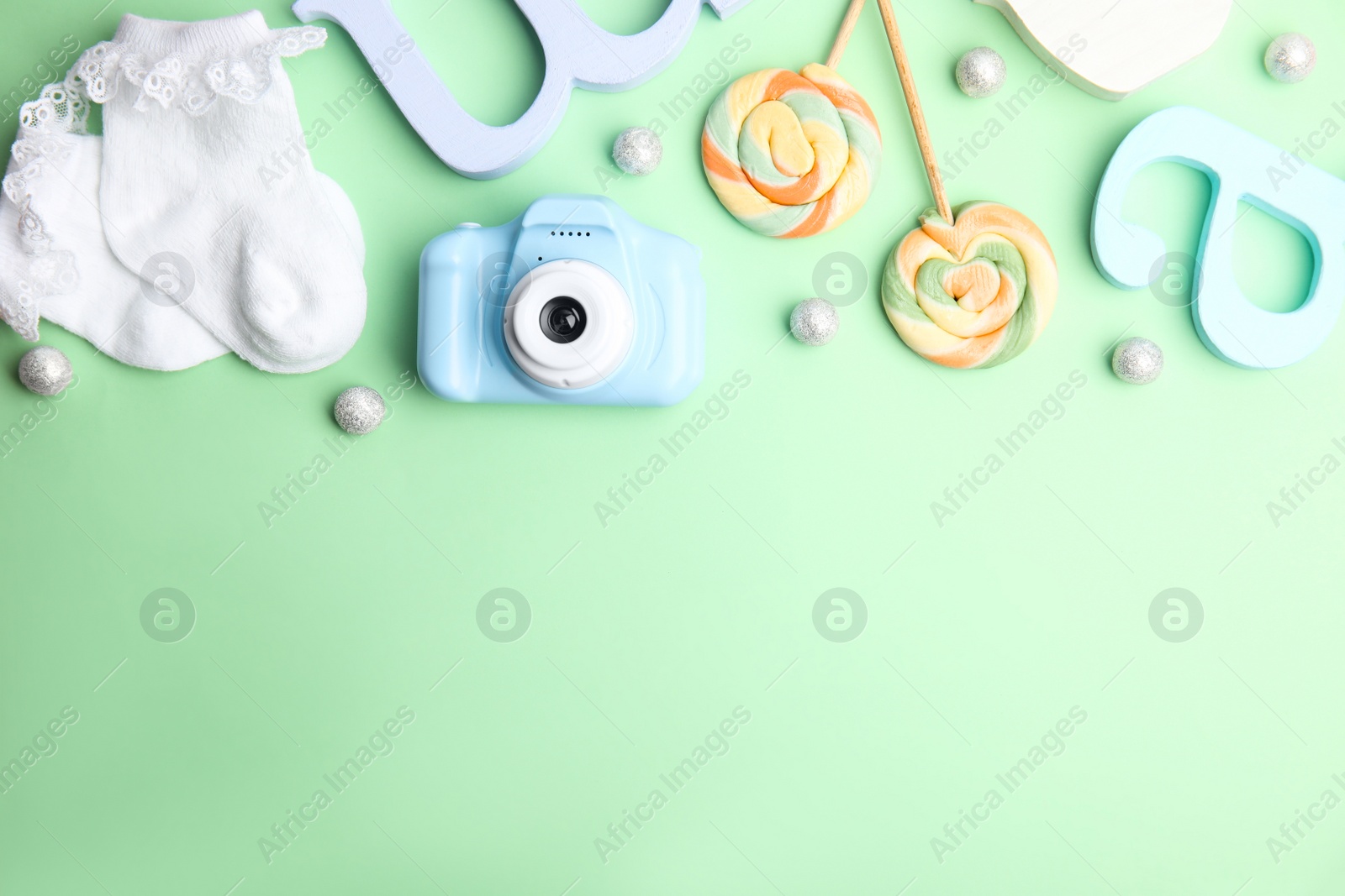 Photo of Flat lay composition with toy camera on light green background, space for text. Future photographer