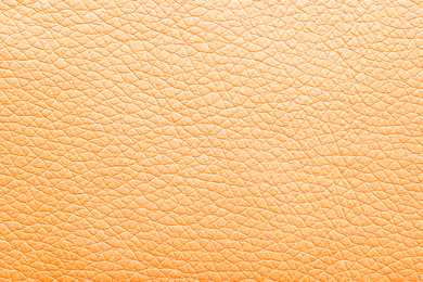 Texture of orange leather as background, closeup