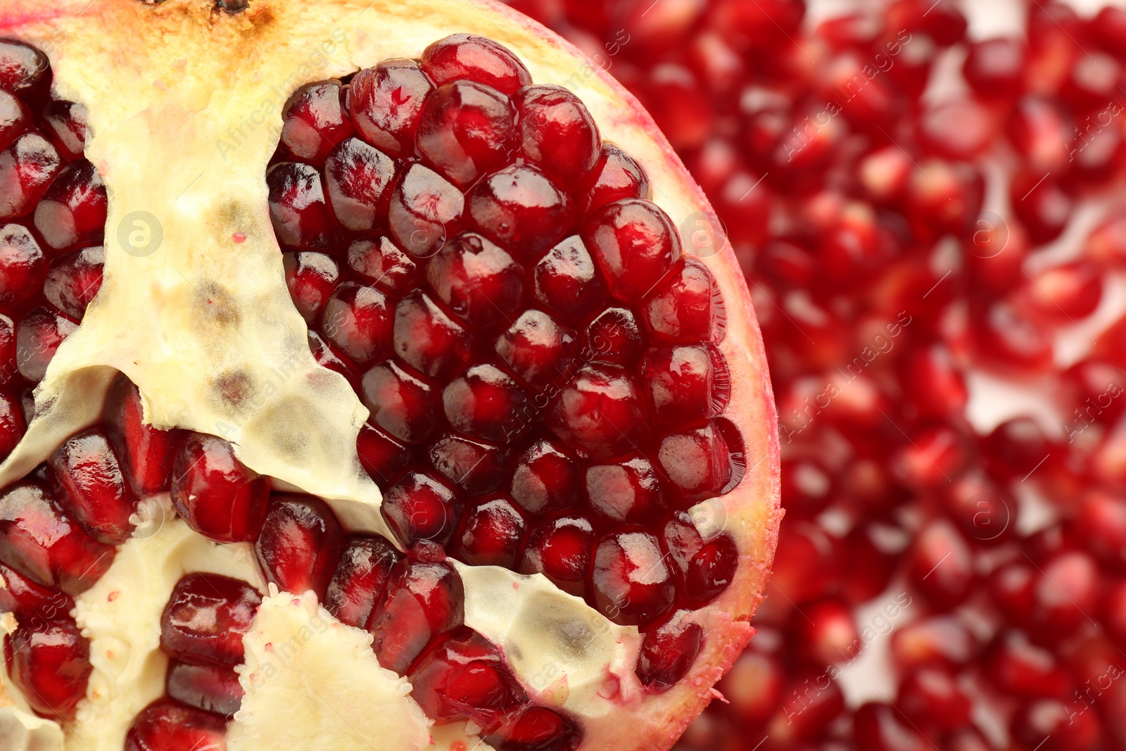 Photo of Ripe juicy red pomegranate on grains grains, top view