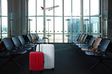 Stylish suitcases in waiting area at airport terminal