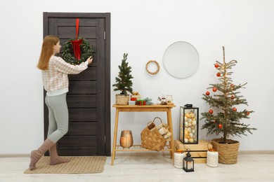 Photo of Woman decorating her entry way for Christmas