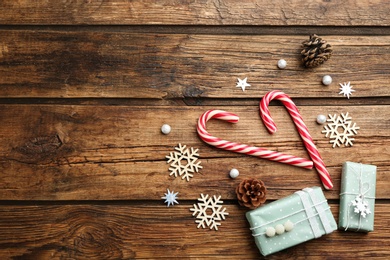 Flat lay composition with candy canes and Christmas decor on wooden background. Space for text