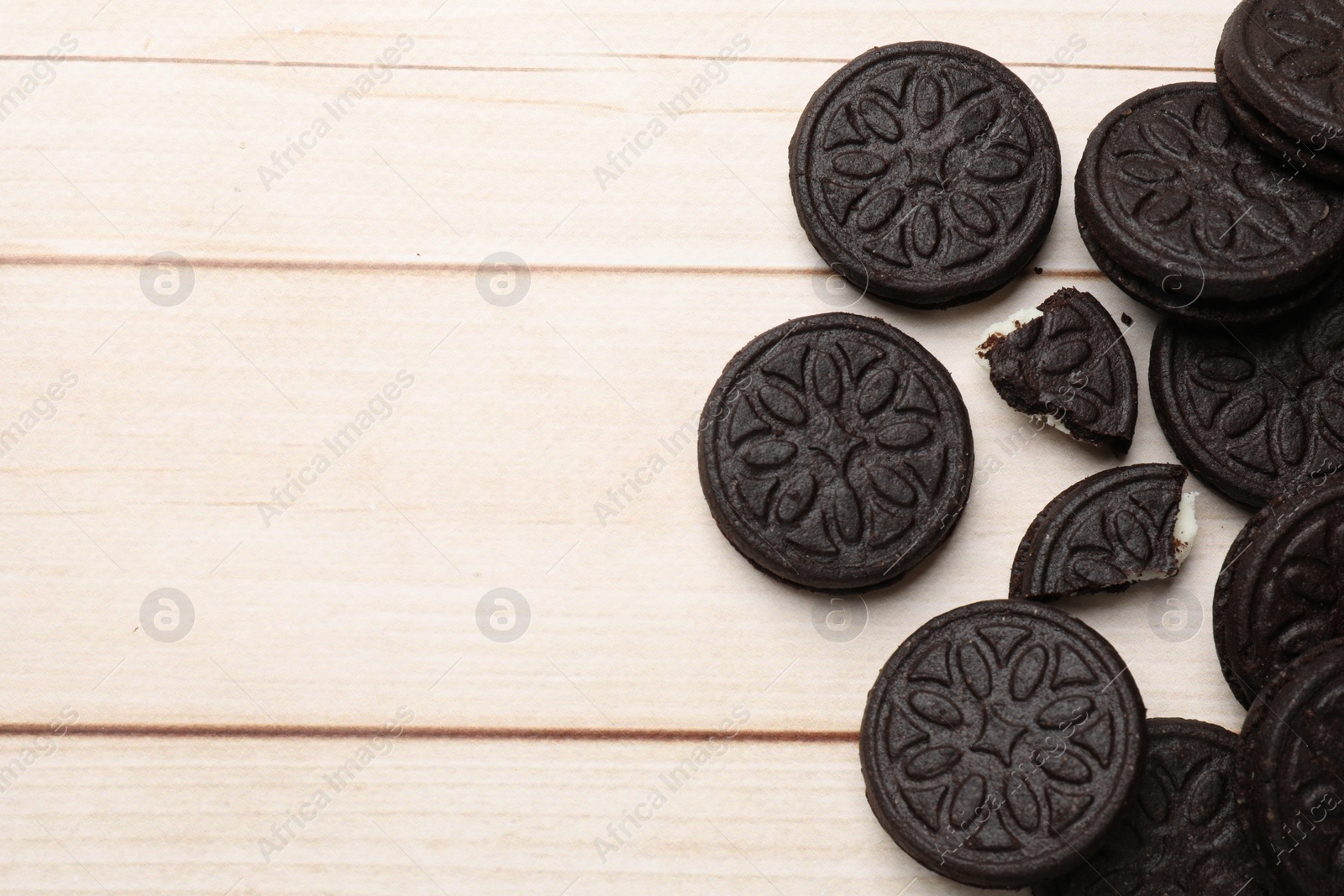 Photo of Tasty sandwich cookies on light wooden table, flat lay. Space for text