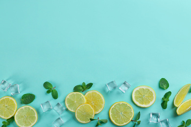 Photo of Lemonade layout with juicy lemon slices, mint and ice cubes on turquoise background, top view. Space for text