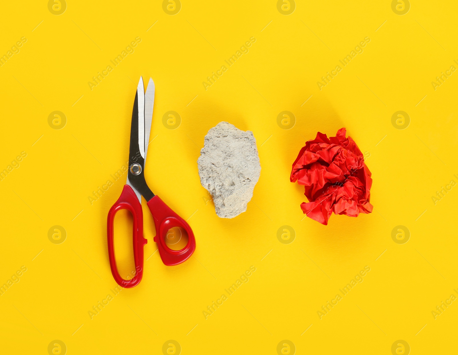 Photo of Flat lay composition with rock, paper and scissors on yellow background