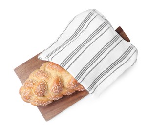 Photo of Homemade braided bread with sesame seeds and napkin isolated on white, top view. Traditional Shabbat challah