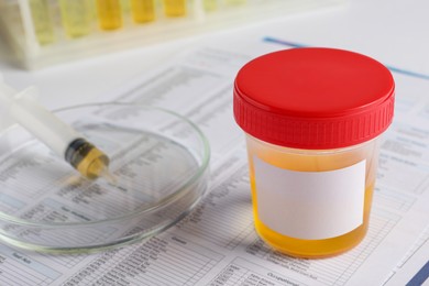 Photo of Container with urine sample on table, closeup. Space for text