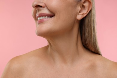 Photo of Mature woman with healthy skin on pink background, closeup