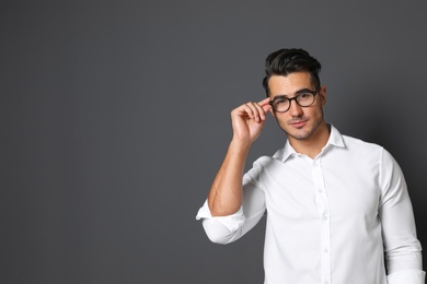 Portrait of handsome young man and space for text on black background