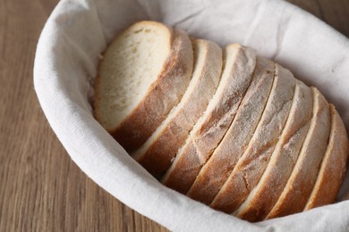 Fresh bread in basket on wooden table, above view