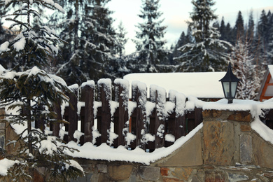 Wooden fence covered with snow outdoors on winter day