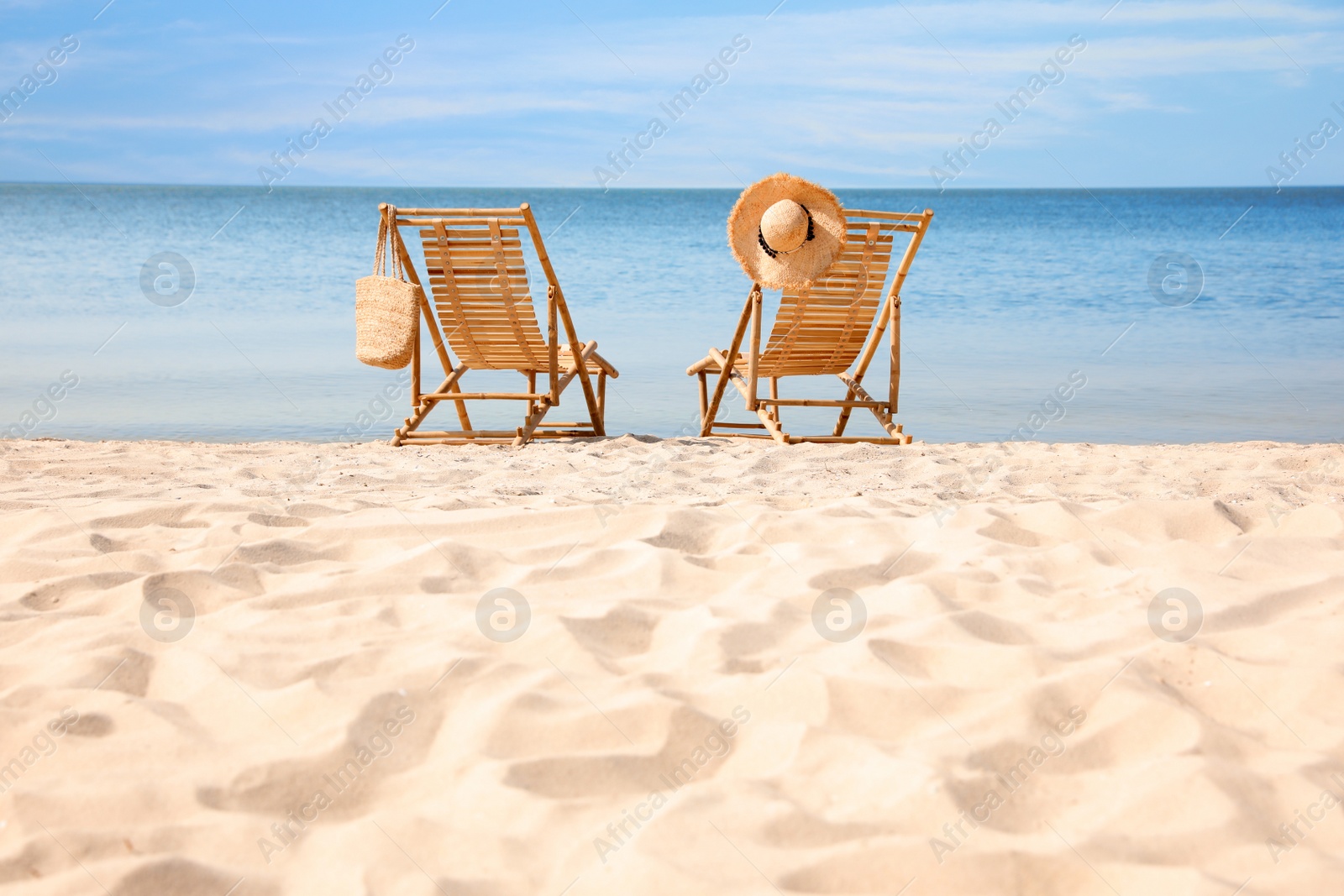 Photo of Wooden deck chairs on sandy beach near sea