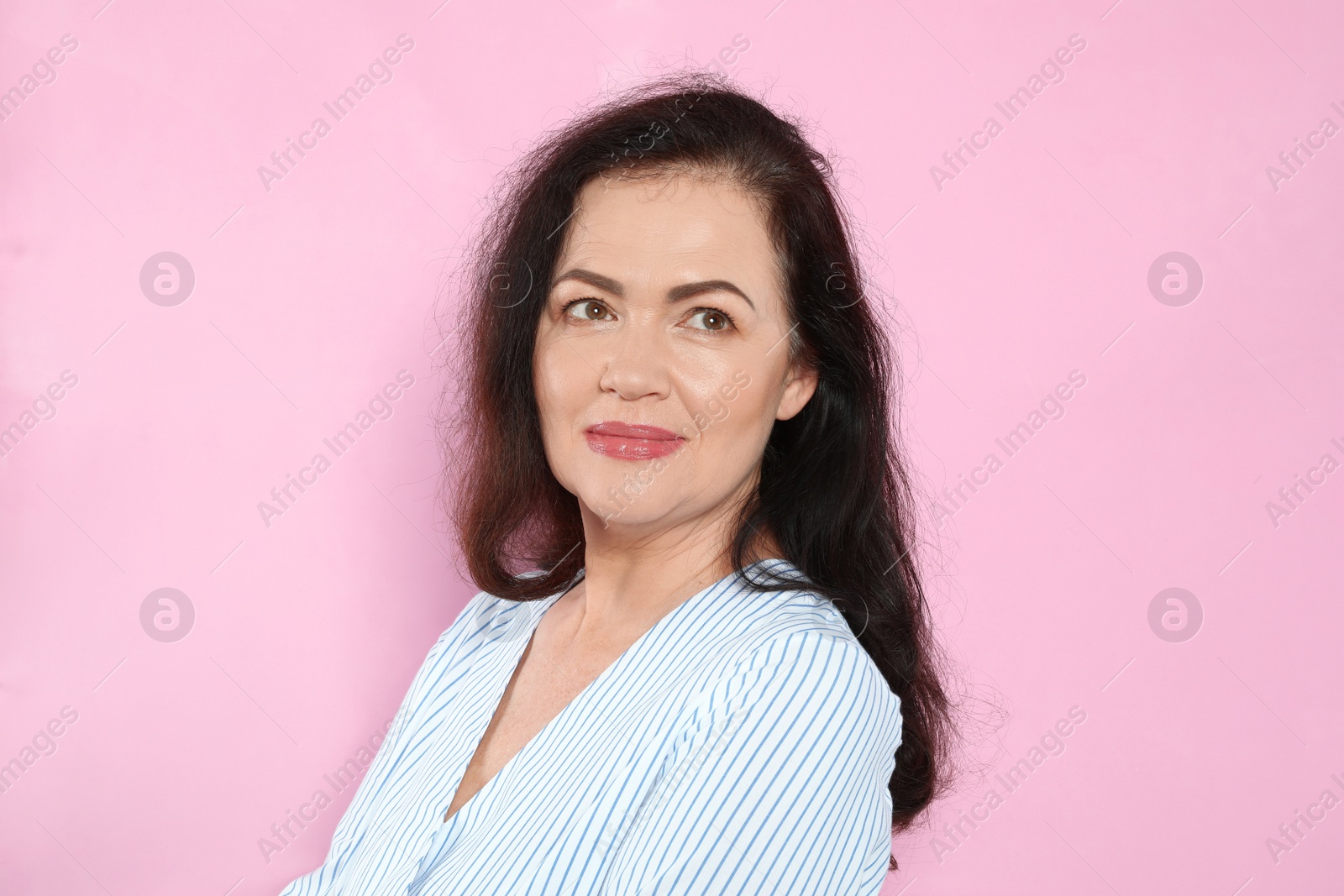 Photo of Portrait of mature woman with beautiful face on pink background