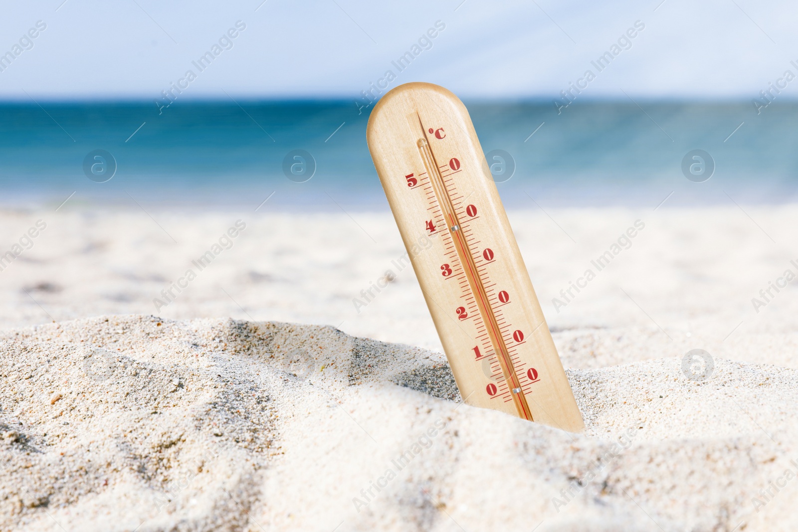 Image of Weather thermometer with high temperature on sandy beach near sea