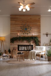 Photo of Beautiful room decorated for Christmas with fir tree garland. Interior design