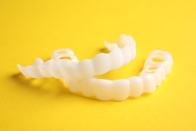 Photo of Dental mouth guards on yellow background, closeup. Bite correction