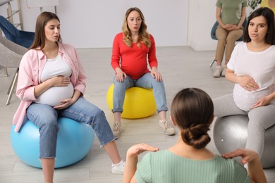 Photo of Group of pregnant women with trainer at courses for expectant mothers indoors