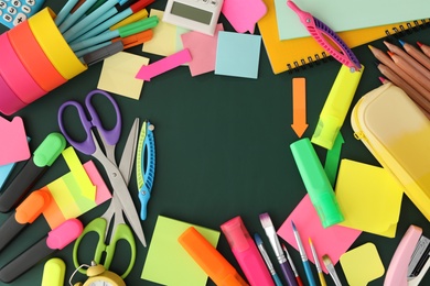 Photo of Frame of different school stationery on green chalkboard, flat lay and space for text. Back to school