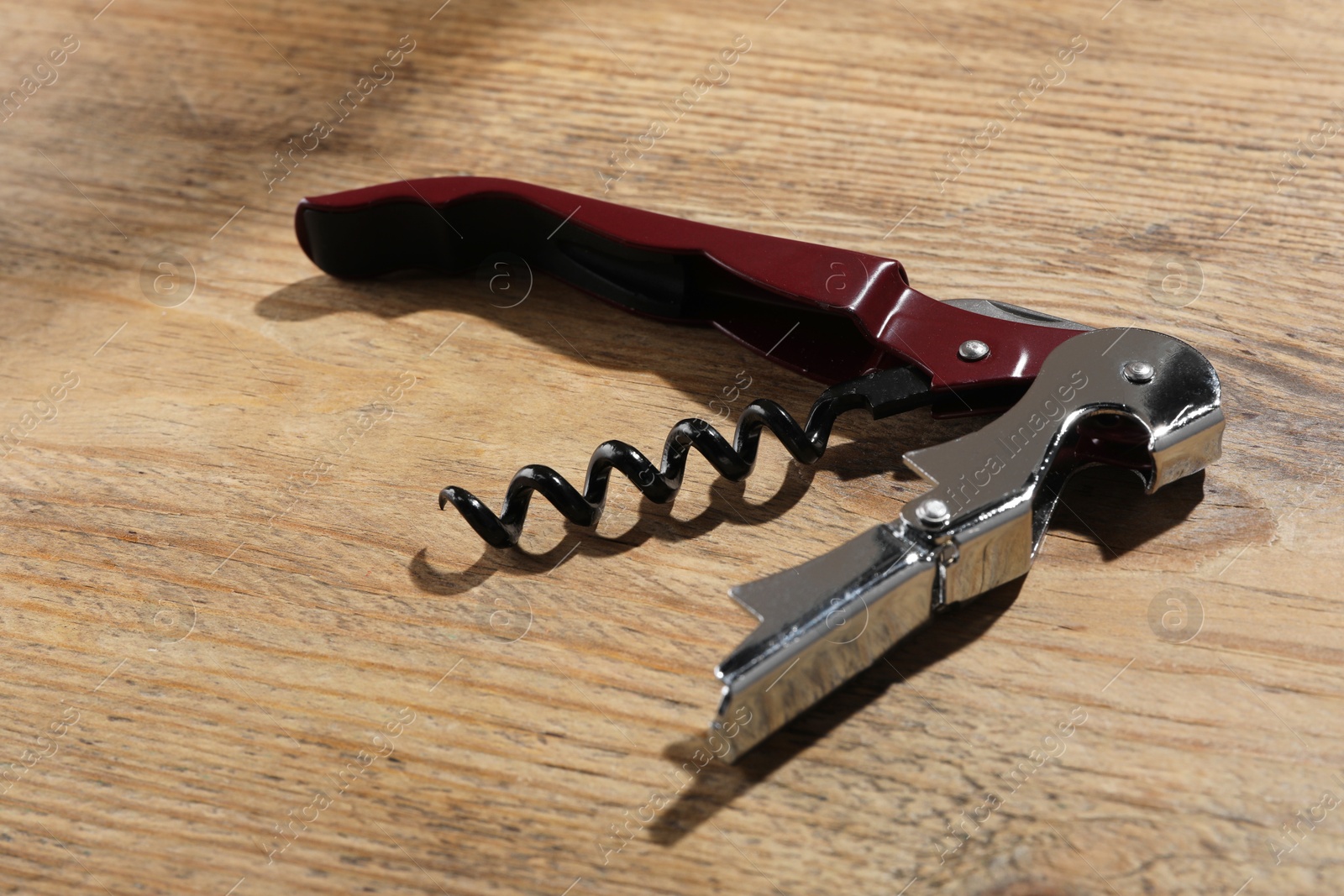 Photo of One corkscrew (sommelier knife) on wooden table