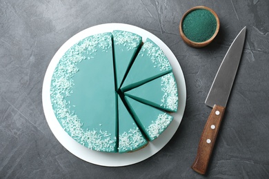 Flat lay composition with tasty spirulina cheesecake on dark grey table