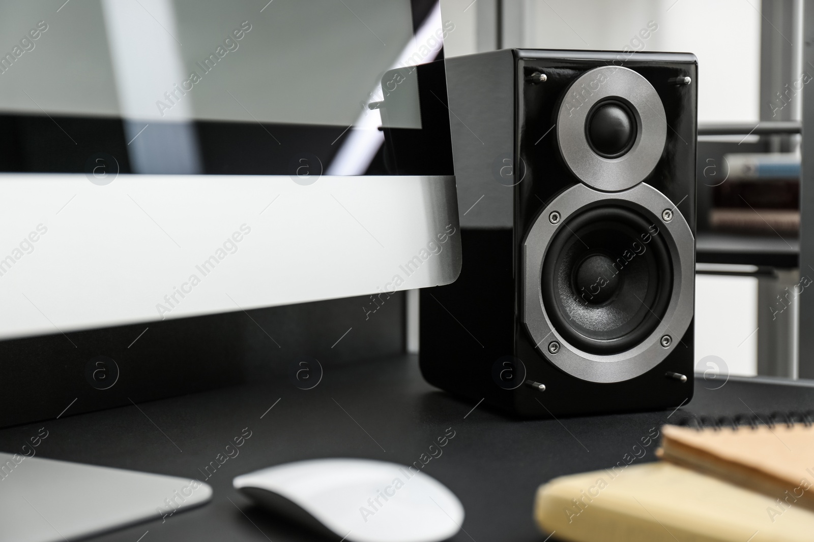 Photo of Modern audio speaker and computer on table indoors