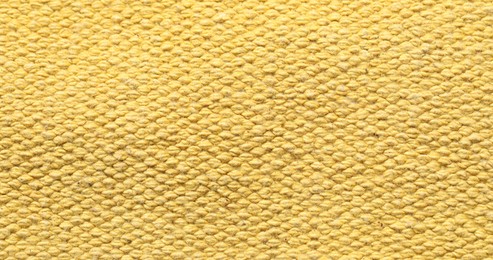 Photo of Texture of soft yellow fabric as background, top view