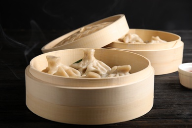 Bamboo steamer with tasty baozi dumplings on table