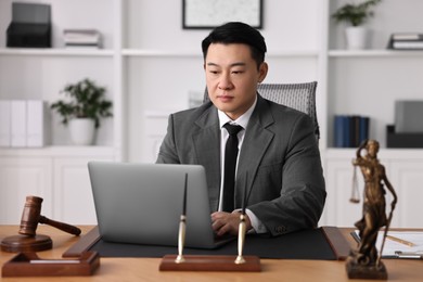 Photo of Notary working with laptop at wooden table in office