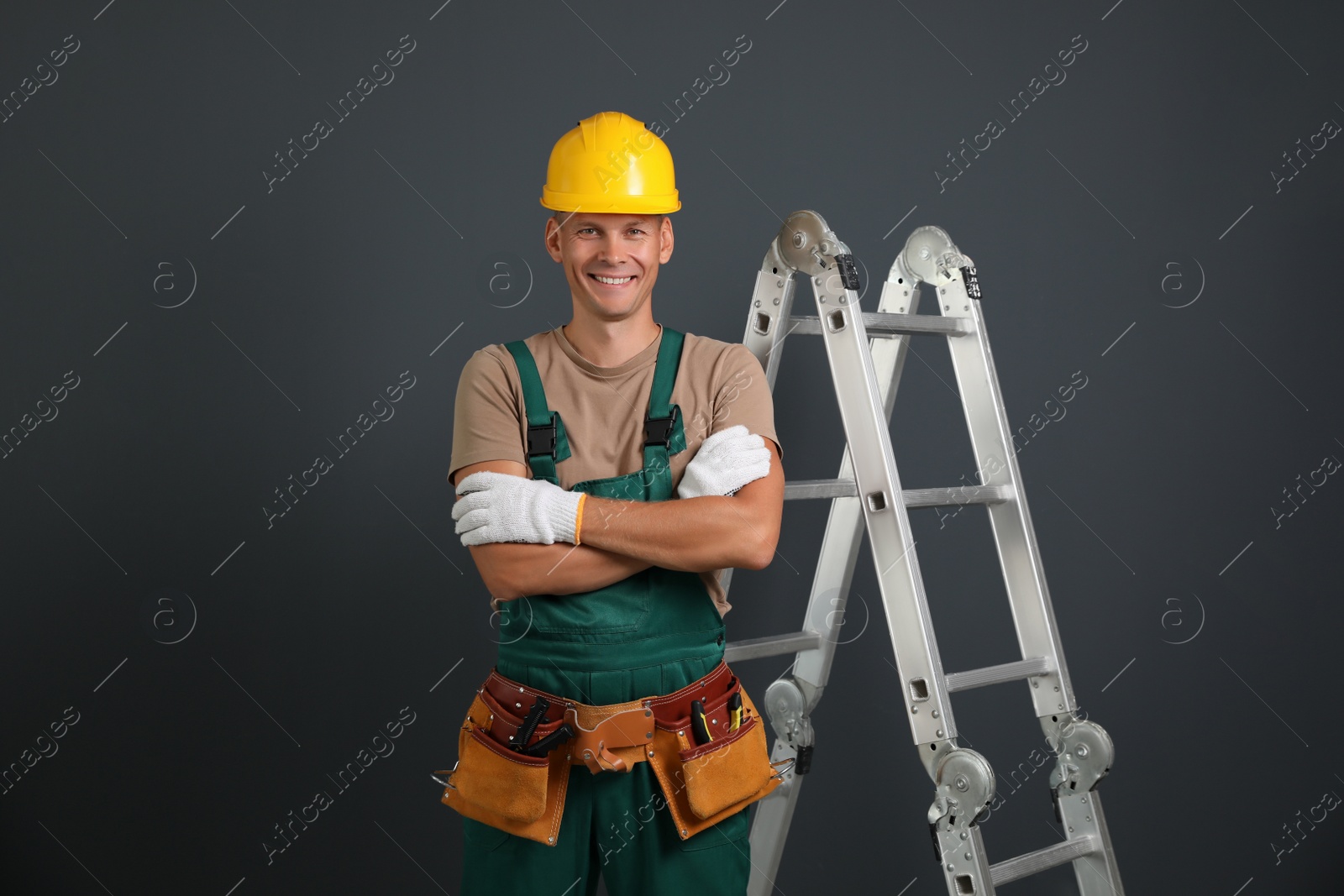 Photo of Professional constructor near ladder on black background