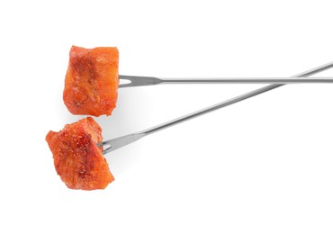 Photo of Fondue forks with pieces of fried meat isolated on white