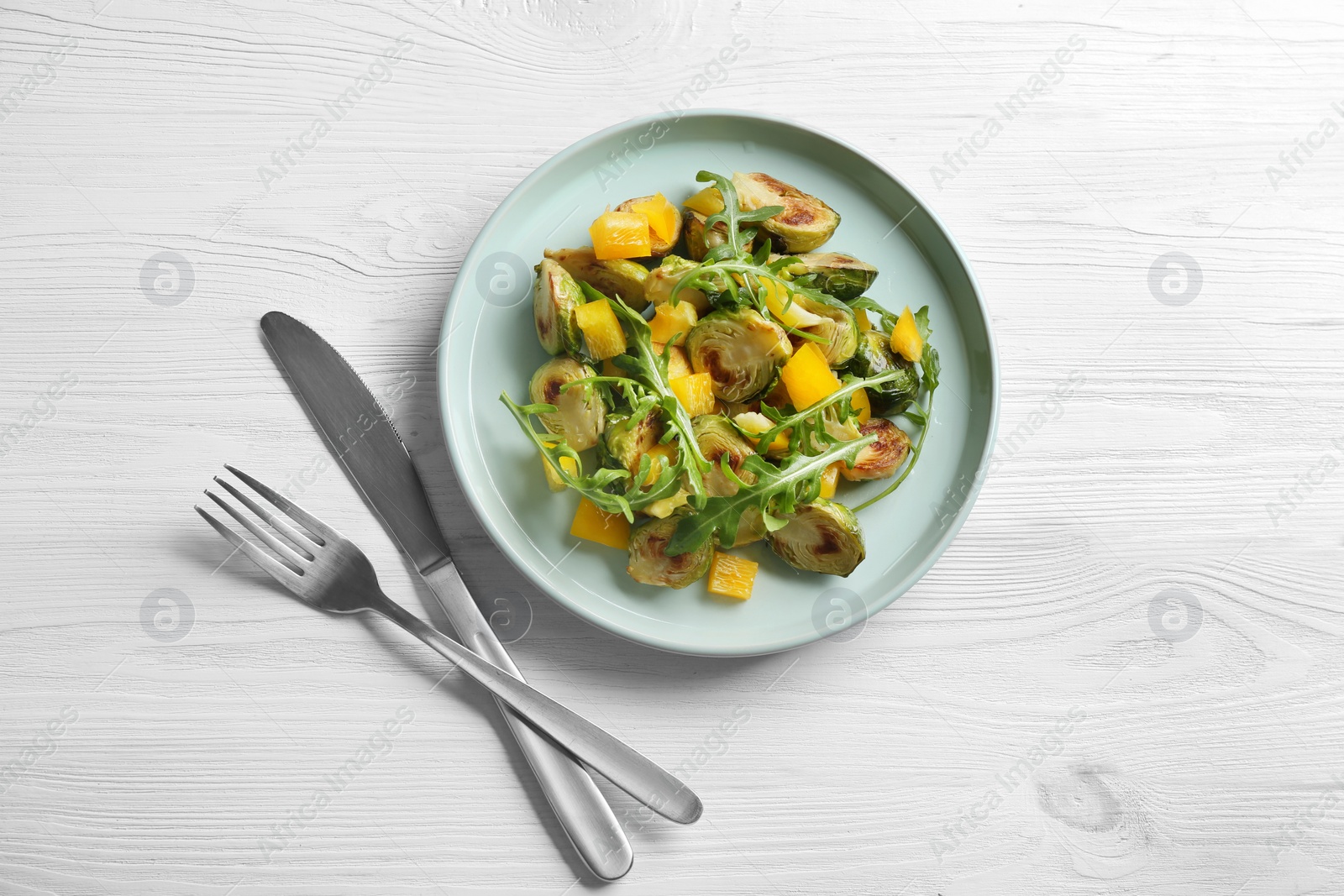 Photo of Delicious salad with roasted Brussels sprouts on white wooden table, flat lay
