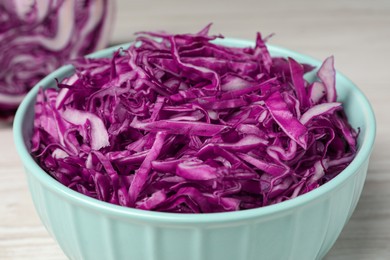 Photo of Tasty fresh shredded red cabbage in bowl, closeup