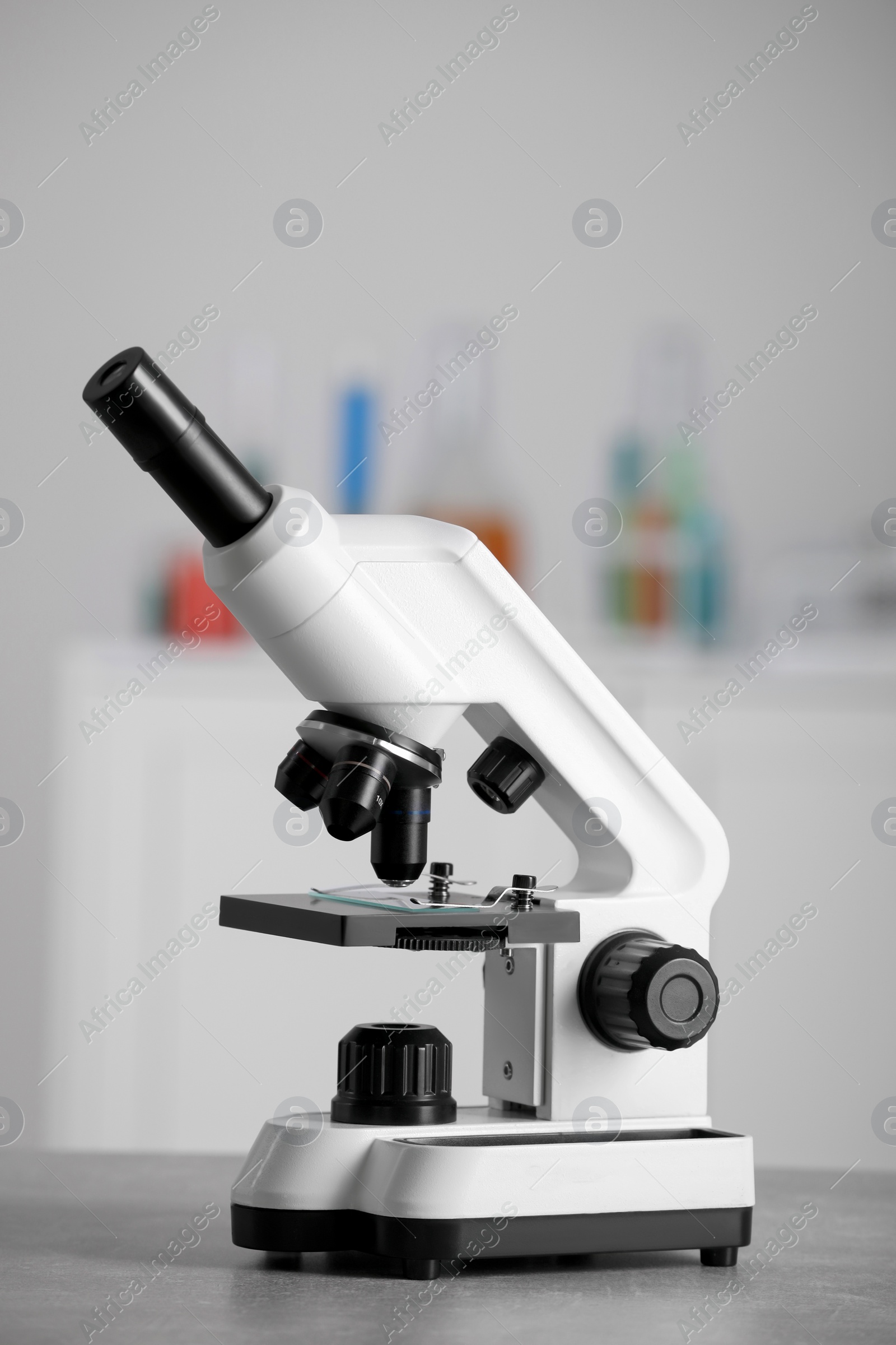 Photo of Modern medical microscope on grey table in laboratory