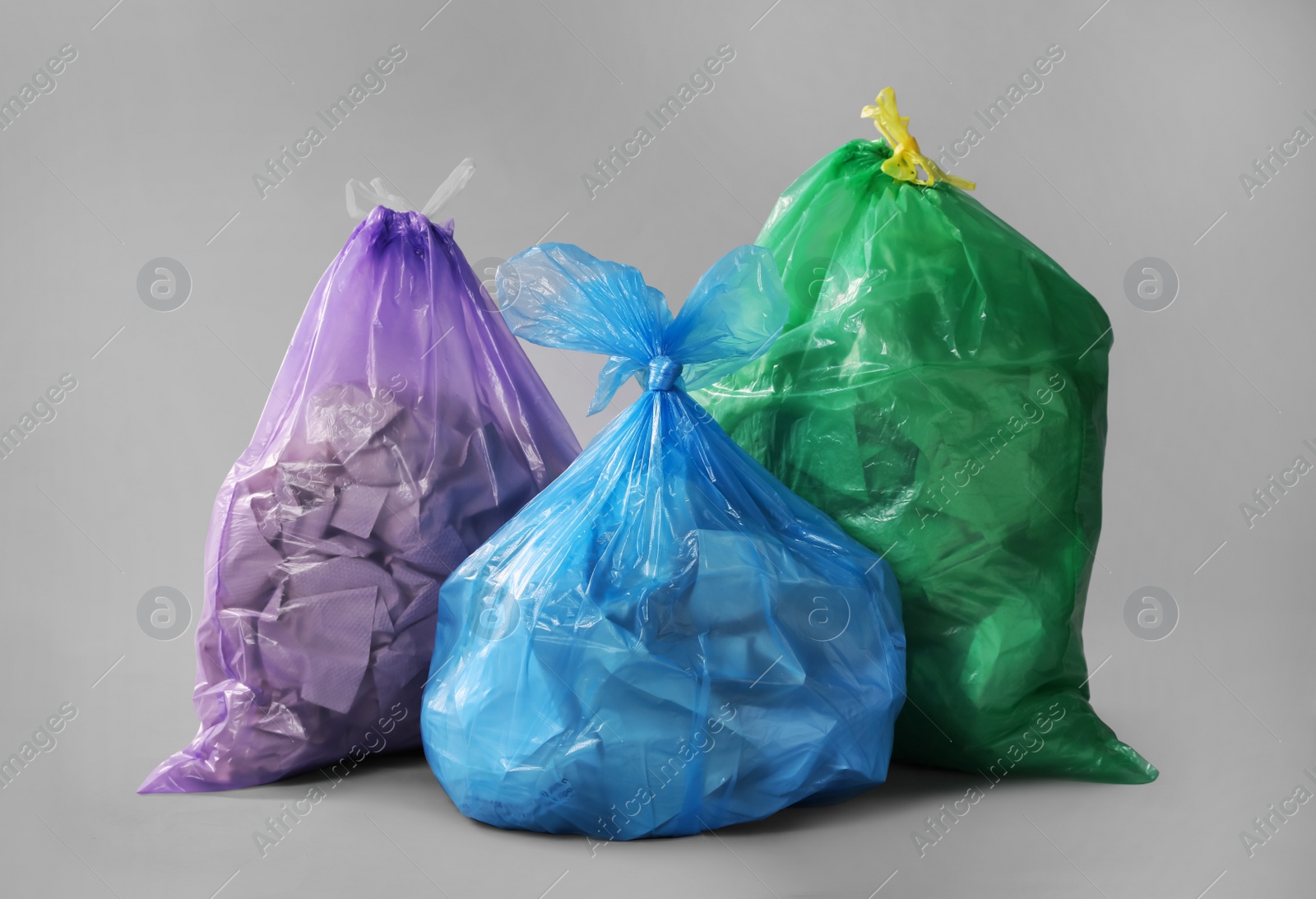 Photo of Trash bags full of garbage on grey background